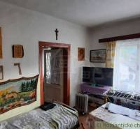 Interior of a family house with wall decorations, a television, and balcony doors.