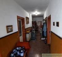 Hallway in a family house with furniture, decorations, and clothes on a hanger.