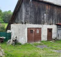 A barn at a family house in Žiar nad Hronom, surrounded by greenery and wood.