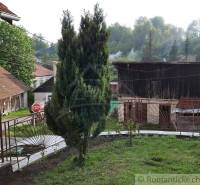 The garden of a family house in Žiar nad Hronom with wooden structures and pleasant fencing.