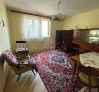 Living room in a family house with a carpet, furniture, table, and chairs.