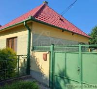 A family house in Dvorníky with a red roof and a green gate.