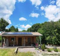 Wooden cabin near Veľký Krtíš with solar panels in a natural environment.