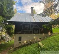 A cabin in the middle of the forest in Kokava nad Rimavicou with an iron roof and wooden walls.