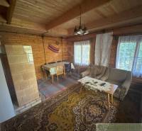 Wooden interior of a cabin with carpets and seating sets.