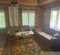 A traditional cottage interior with wooden paneling and rustic furniture.