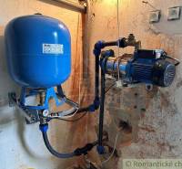 A device with a blue pressure tank in the technical room of the cottage.