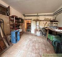 A cottage with a tool shed, shelves, and wooden floors.