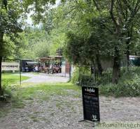 A forest cabin in Bratislava - Lamač with a seating area, surrounded by trees and greenery.