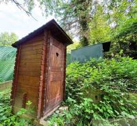 A wooden latrine in a natural setting near a cabin in Bratislava - Lamač.