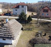 A family house in Nová Sedlica with a traditional roof and surrounding houses in the background.