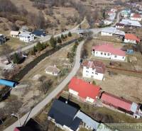A view of family houses surrounded by nature and a river in Nová Sedlica.