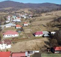 Family houses in Nová Sedlica set in a hilly landscape with fields.