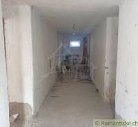 The interior of a family house with a long hallway and visible construction mess.