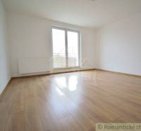 An empty room with a wooden floor and a large window in a family house.