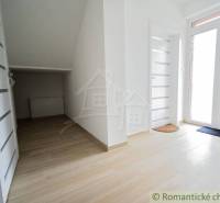 A hallway in a family house with white doors and a light floor.