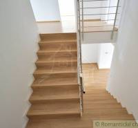 A staircase with wooden steps and a metal railing in a family house.