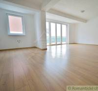 A spacious living room in a family house with wooden flooring and large windows.