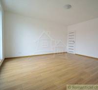 Spacious room with wooden floor and large window in a family house.