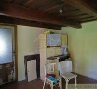 The interior of a family house with a wooden ceiling and basic furniture creates a retro atmosphere.
