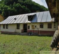 A family house in Hačava surrounded by greenery, with a gable roof, and a mowed lawn in front of it.