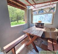 Rustic wooden table and benches with a view of the garden.