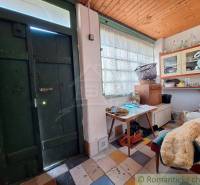 Interior of a cabin with wooden doors, a table, and vintage furniture, cozy atmosphere.