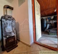 The interior of the cottage with tiles next to the door leading to the storage space.