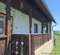 A wooden veranda at the cottage in Podkriváň with a view of the surrounding nature.