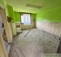 An interior with unplastered walls and an old stove in a family house.
