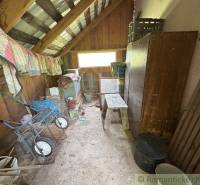 Storage space in a family house with a wooden attic, full of various tools.