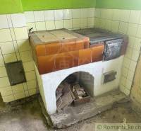 Traditional stove in the interior of a family house with cladding in warm shades.