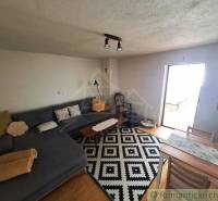 Living room with a corner sofa and a patterned carpet in a family house.