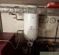 The boiler room of a family house in Telgárt contains a water heater and piping.