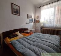 Bedroom with paintings, decorations, a window, and a bed in a family house. A romantically coordinated space.