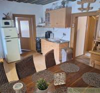 Rustic kitchen and family house with wooden furniture, woven decorations, and a refrigerator.