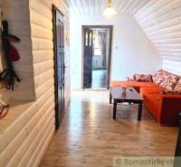 A family house with a wooden interior, an orange sofa, and furnishings in a rustic style.