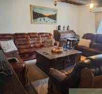 Leather sofas and rustic furniture create a cozy atmosphere in the living room of the family house.
