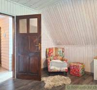 A room in a family house with wooden paneling, an armchair, and a table in Scandinavian style.