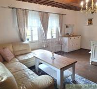 A bright room with a fireplace, a comfortable sofa, and an elegant chandelier in a family house.