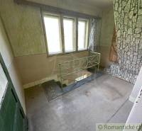 Interior of an older house with a staircase and a stone-clad wall. Family house.