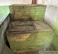 The green brick oven with a worn appearance aptly illustrates the atmosphere of an old family house.