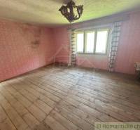 A place with wooden flooring, pink walls, and a window, suitable for a family house.