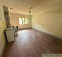 The interior of a country family house with a wooden floor and an old stove.