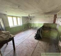 Abandoned room in a family house, green walls, wooden furniture, old stone stove.