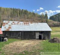 An old barn with a tin roof in a mountainous landscape. Rustic atmosphere and a family house.