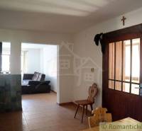 In the family house, there is a kitchen with chairs, an armchair, and interior doors.
