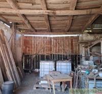 A barn by the family house with old wood, tanks, and an antique workbench.