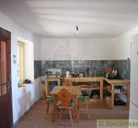 Cottage-style kitchen, wooden furniture, simple equipment, family house, pleasant atmosphere.