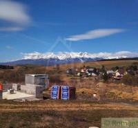 Building plot with a beautiful view of the mountains and a partially constructed family house in nature.
